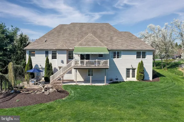 a view of a house with a yard potted plants and a large tree