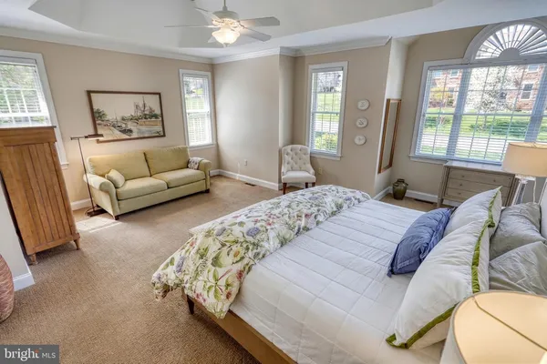 a bedroom with a bed mirror and couch