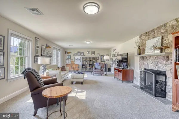 a living room with furniture a rug and a lamp