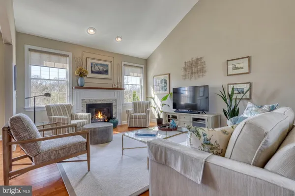 a living room with furniture a flat screen tv and kitchen view