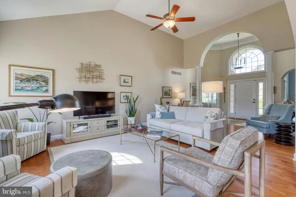 a living room with furniture a chandelier and a dining table
