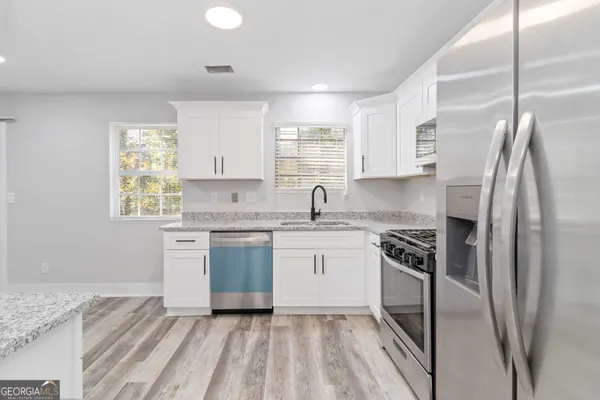 a kitchen with stainless steel appliances granite countertop a sink stove and refrigerator