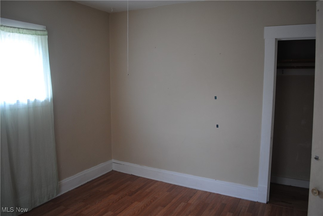 841 Whitcomb Road Cleveland, OH 44110 - Photo 21 of 30 Unfurnished bedroom with dark wood-style flooring and a closet