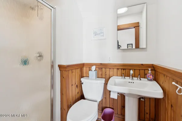 a bathroom with a sink a toilet and a mirror