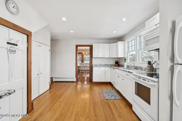a kitchen with white cabinets and white appliances
