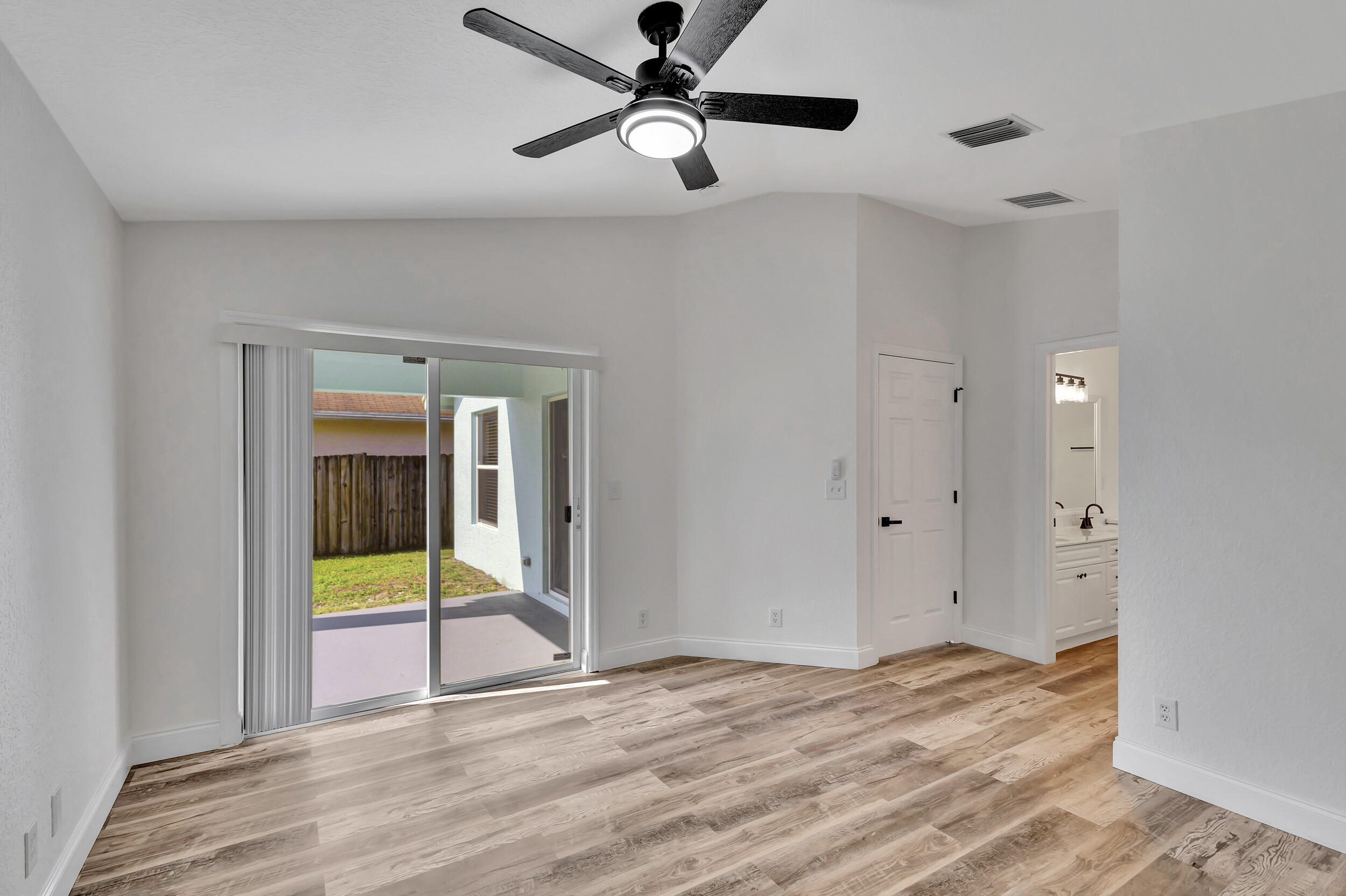 6746 3rd Street Limestone Creek, FL 33458 - Photo 25 of 60 a view of an empty room with wooden floor and a ceiling fan