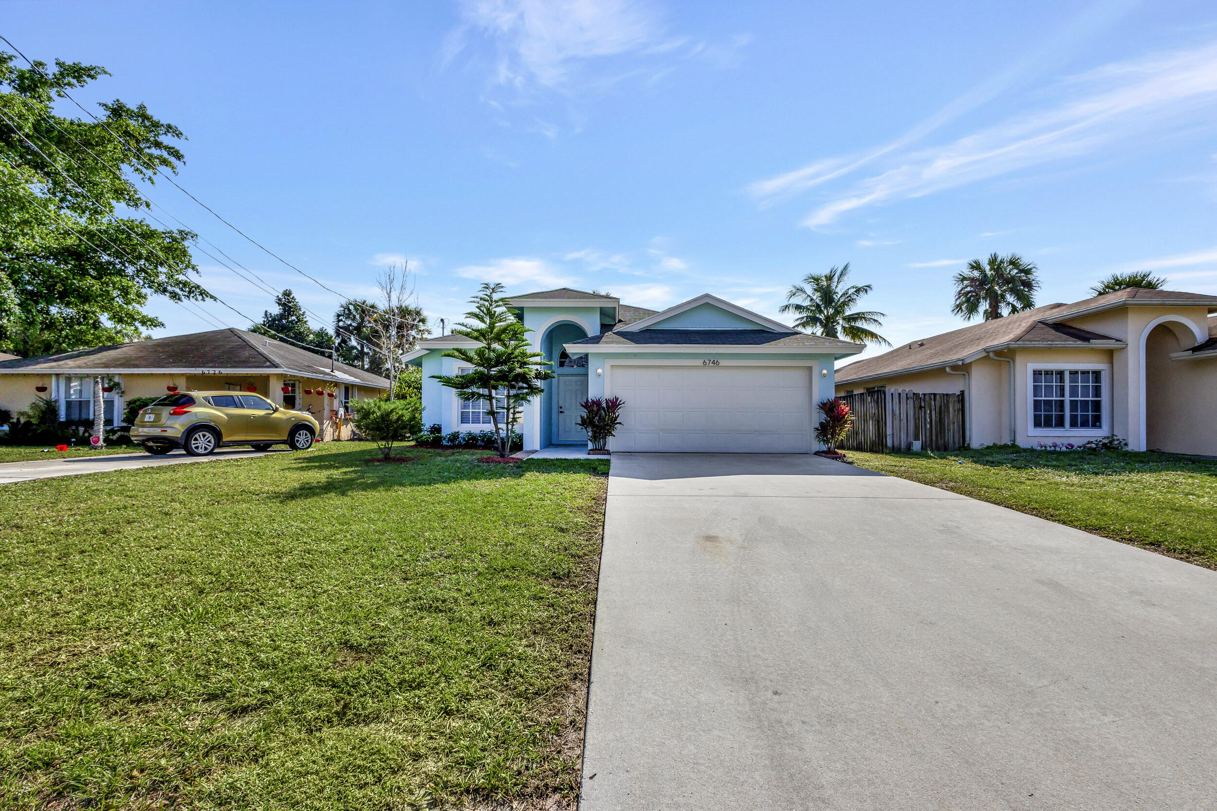 6746 3rd Street Limestone Creek, FL 33458 - Photo 3 of 60 a front view of a house with a yard and garage