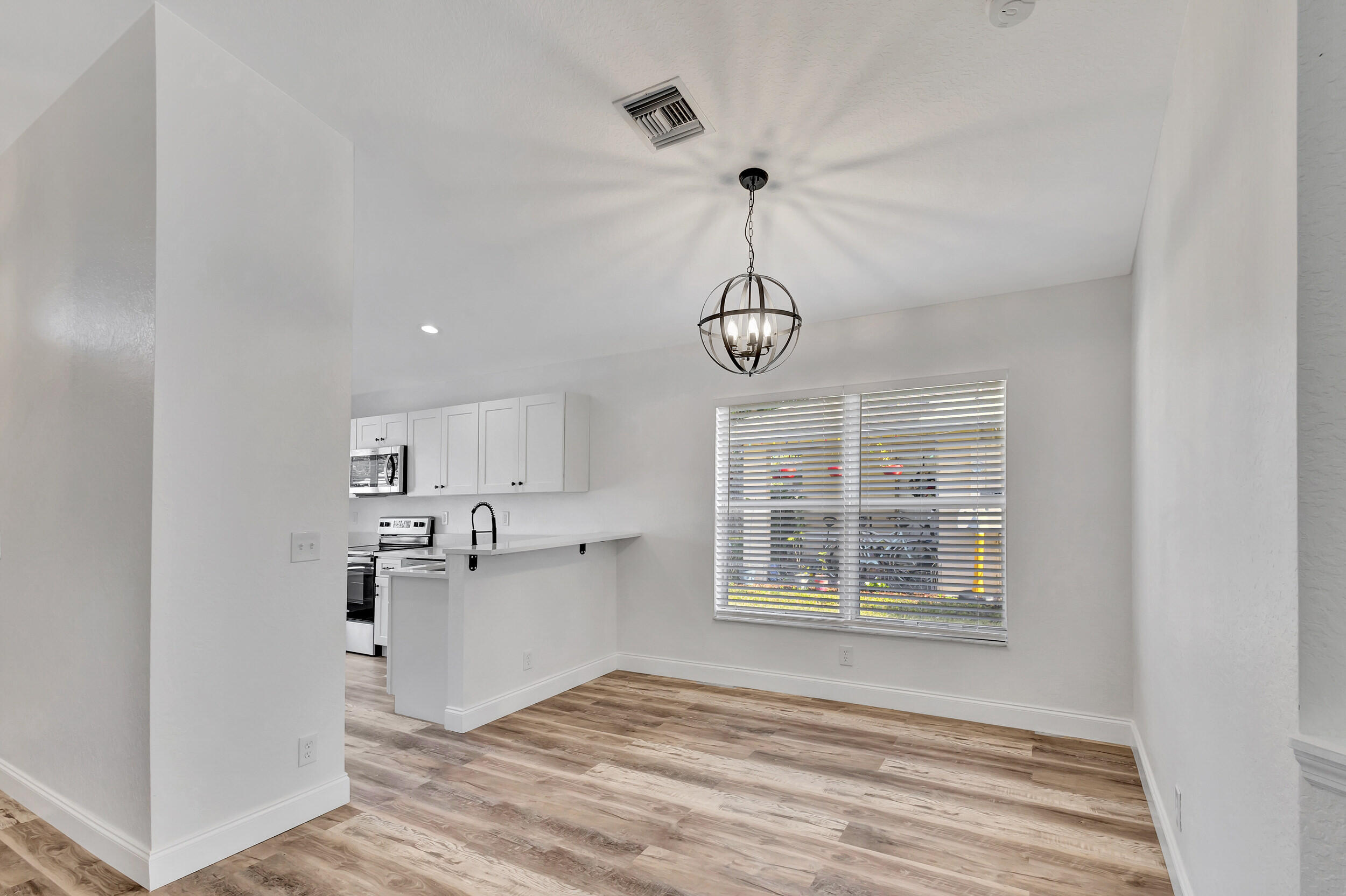 6746 3rd Street Limestone Creek, FL 33458 - Photo 7 of 60 a view of a kitchen with a window and wooden floor