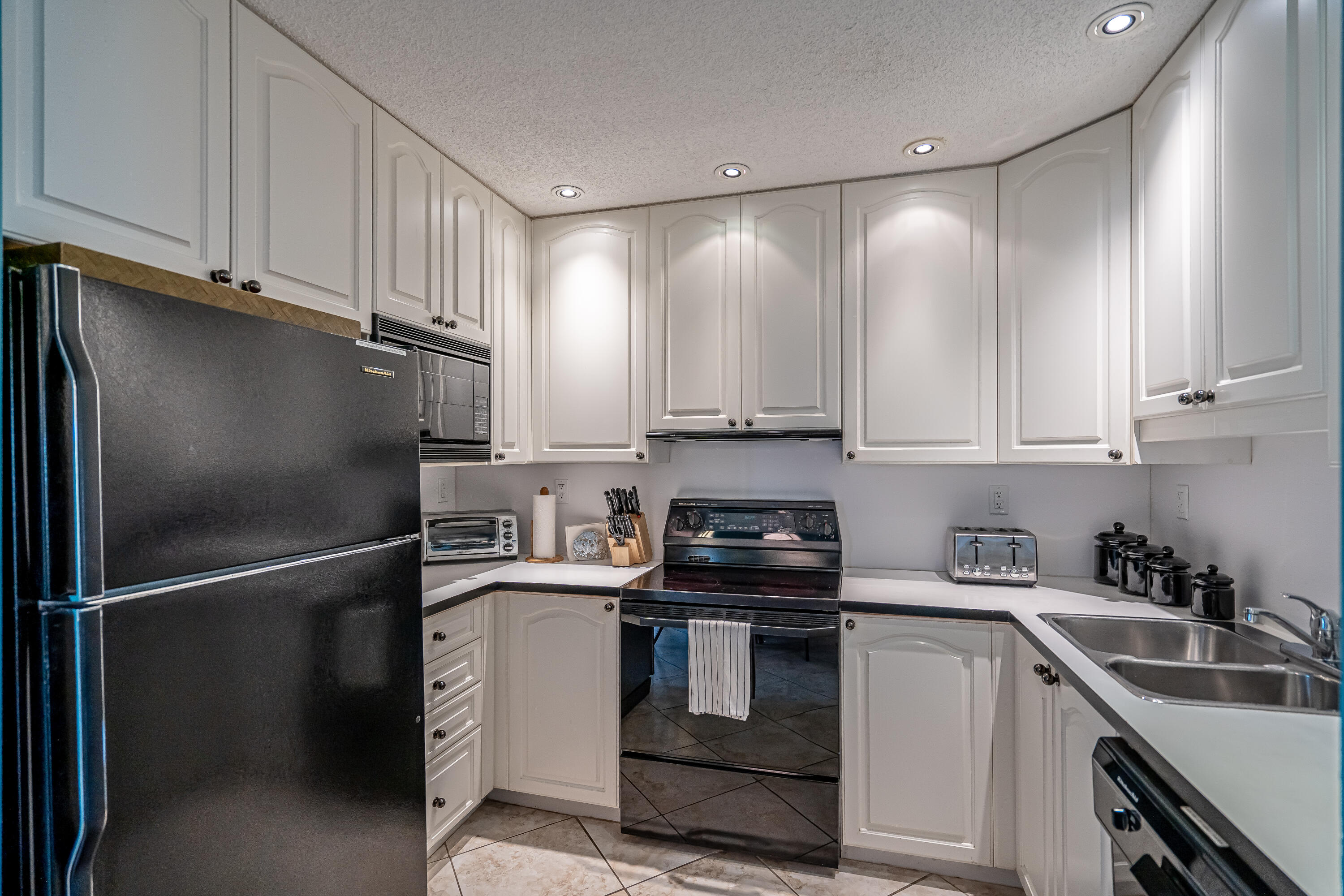 a kitchen with kitchen island white cabinets stainless steel appliances and sink