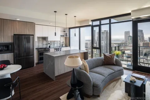 a kitchen with stainless steel appliances granite countertop a refrigerator a sink dishwasher a stove and a dining table with wooden floor