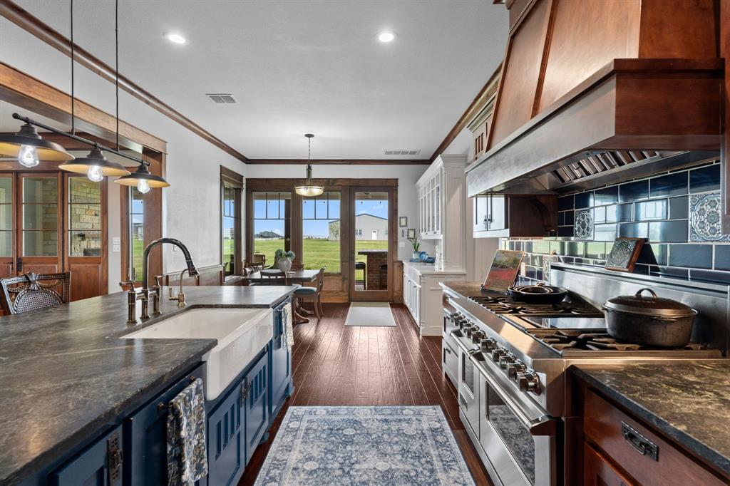 1206 Jc Maples Road Gunter, TX 75058 - Photo 9 of 40 a kitchen with stainless steel appliances granite countertop a stove and a sink