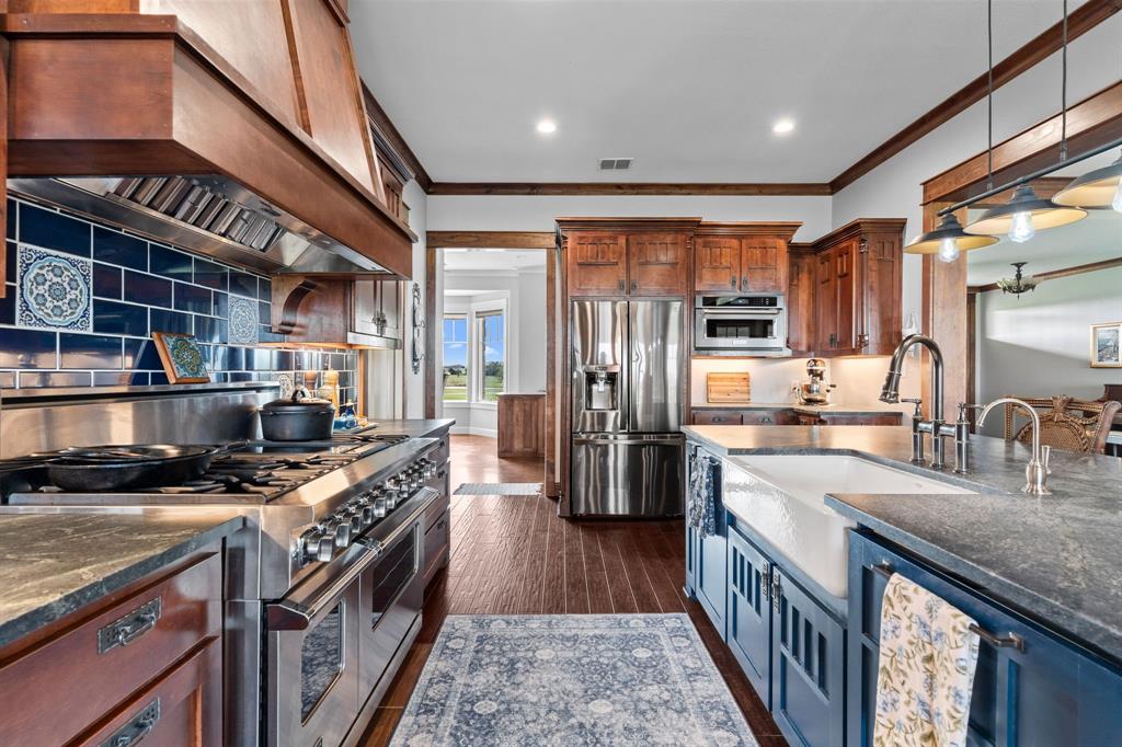 1206 Jc Maples Road Gunter, TX 75058 - Photo 13 of 40 a kitchen with stainless steel appliances granite countertop a stove a sink and a refrigerator