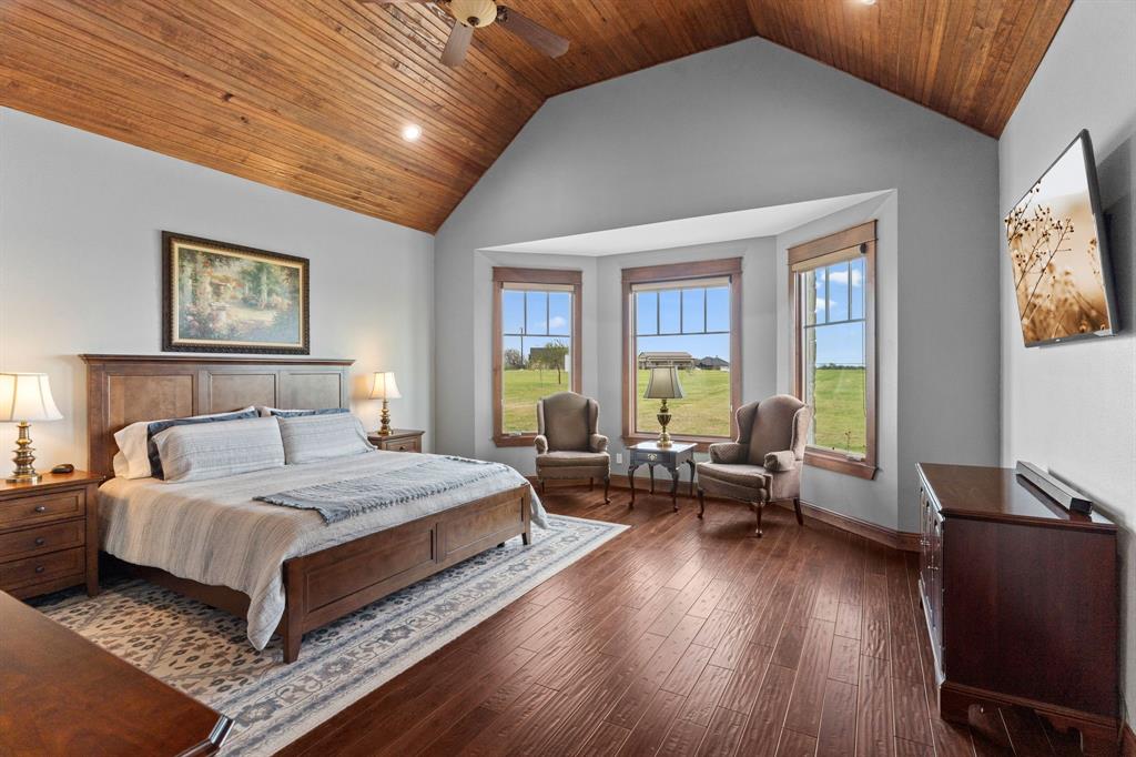 1206 Jc Maples Road Gunter, TX 75058 - Photo 14 of 40 a bedroom with a large bed and wooden floor