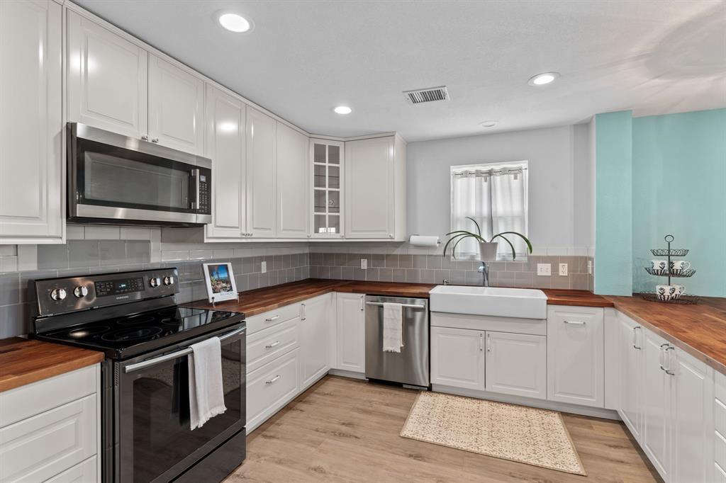 1206 Jc Maples Road Gunter, TX 75058 - Photo 30 of 40 a kitchen with stainless steel appliances granite countertop a sink a stove top oven and cabinets