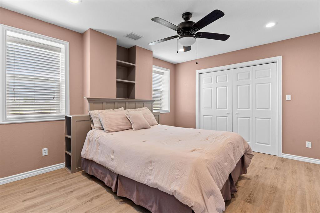 1206 Jc Maples Road Gunter, TX 75058 - Photo 31 of 40 a bedroom with a large bed chandelier and a window