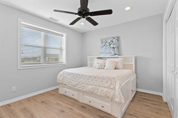 a bedroom with a large bed chandelier and a window
