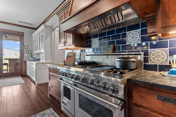 a kitchen with stainless steel appliances granite countertop a stove a sink and a refrigerator