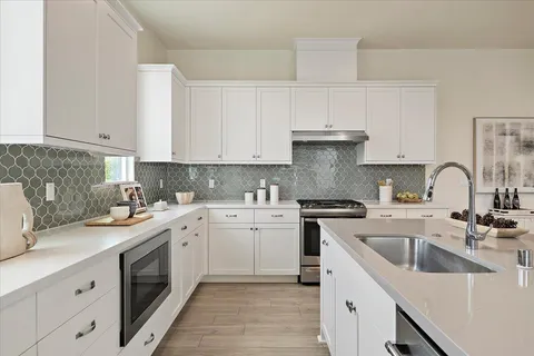 a kitchen with granite countertop a sink stove and cabinets