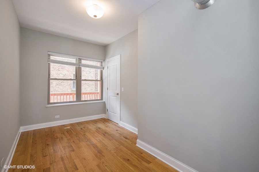 637 East 49th Street, Unit 3 Chicago, IL 60615 - Photo 4 of 7 an empty room with wooden floor and windows