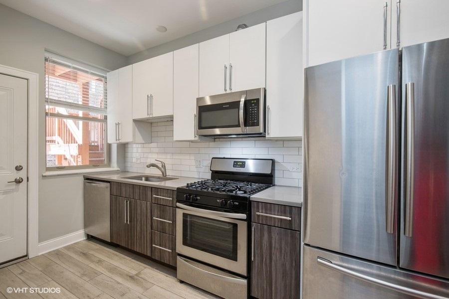 637 East 49th Street, Unit 3 Chicago, IL 60615 - Photo 5 of 7 a kitchen with stainless steel appliances a stove microwave and sink
