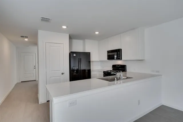 a kitchen with stainless steel appliances a refrigerator sink and microwave