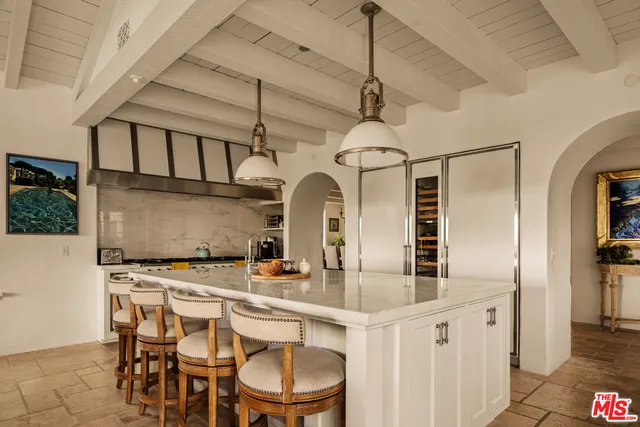 a kitchen with stainless steel appliances a counter space a sink refrigerator and cabinets