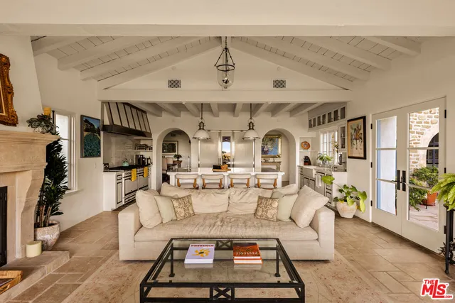 a living room with furniture a chandelier and a rug
