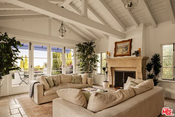 a living room with furniture large window and fireplace