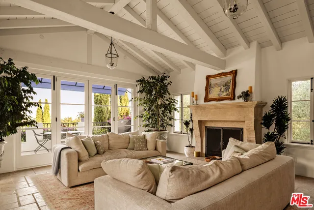 a living room with furniture large window and fireplace