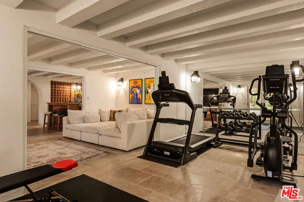 a living room with furniture and gym equipment