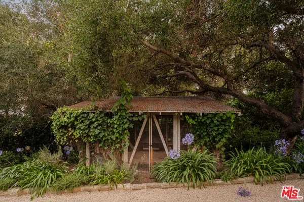 a view of a white house with a big yard and potted plants