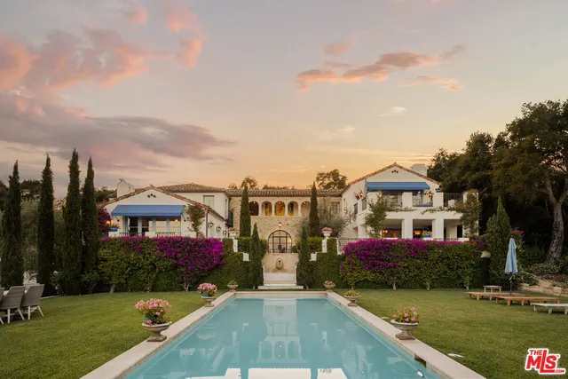 a view of a house with large windows and a yard