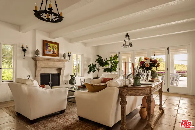 a living room with furniture a chandelier and a fireplace