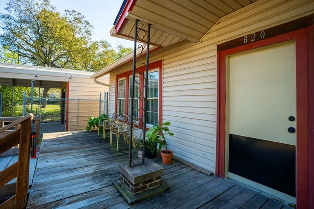 a porch with chairs and wooden floor