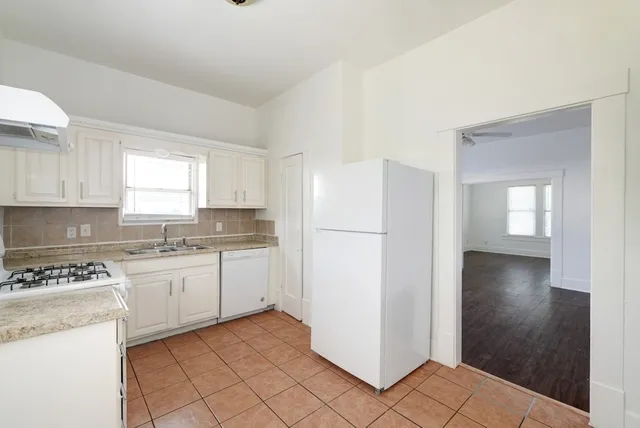 a kitchen with a white cabinets and white appliances