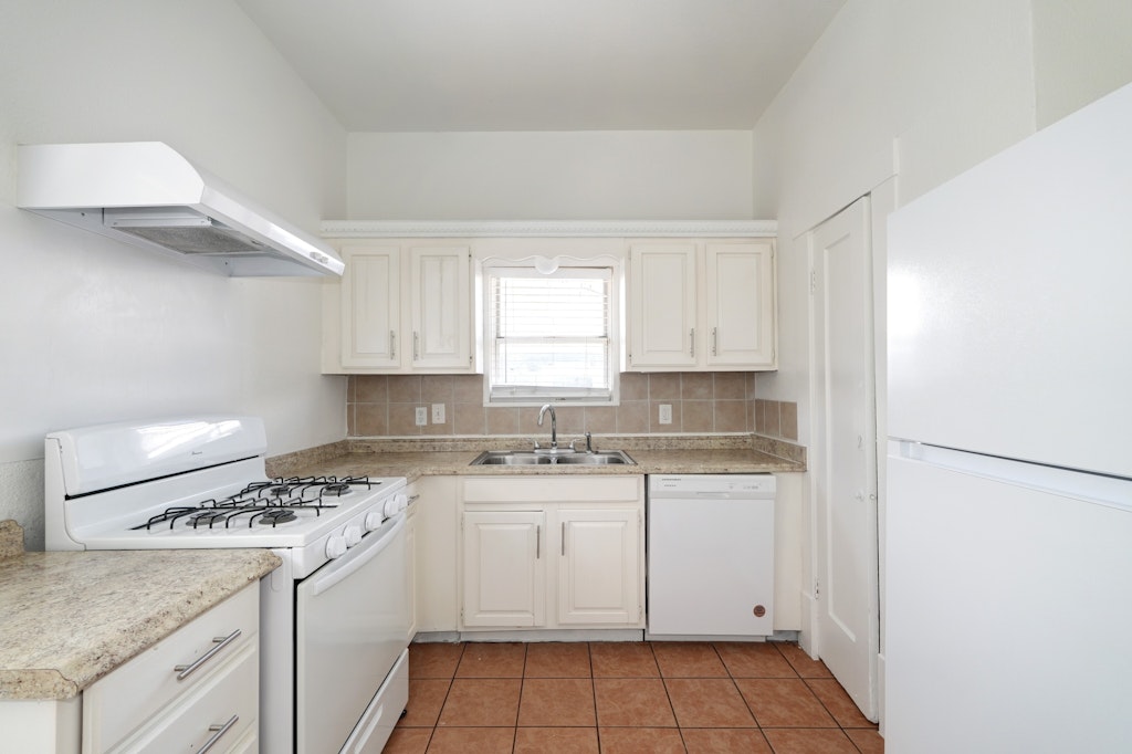 1205 East 12th Street Austin, TX 78702 - Photo 9 of 15 a kitchen with a stove a sink and a refrigerator