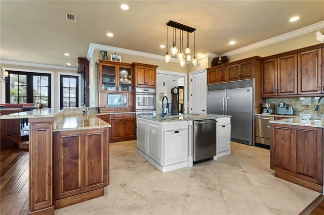 a kitchen with stainless steel appliances granite countertop a sink a stove and a refrigerator
