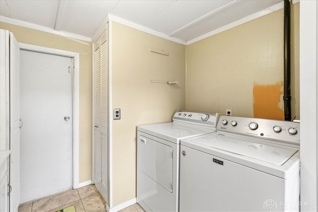 246 North Orchard Island Road Russells Point, OH 43348 - Photo 19 of 43 This functional space features laundry appliances and tiled flooring, ready for daily tasks.