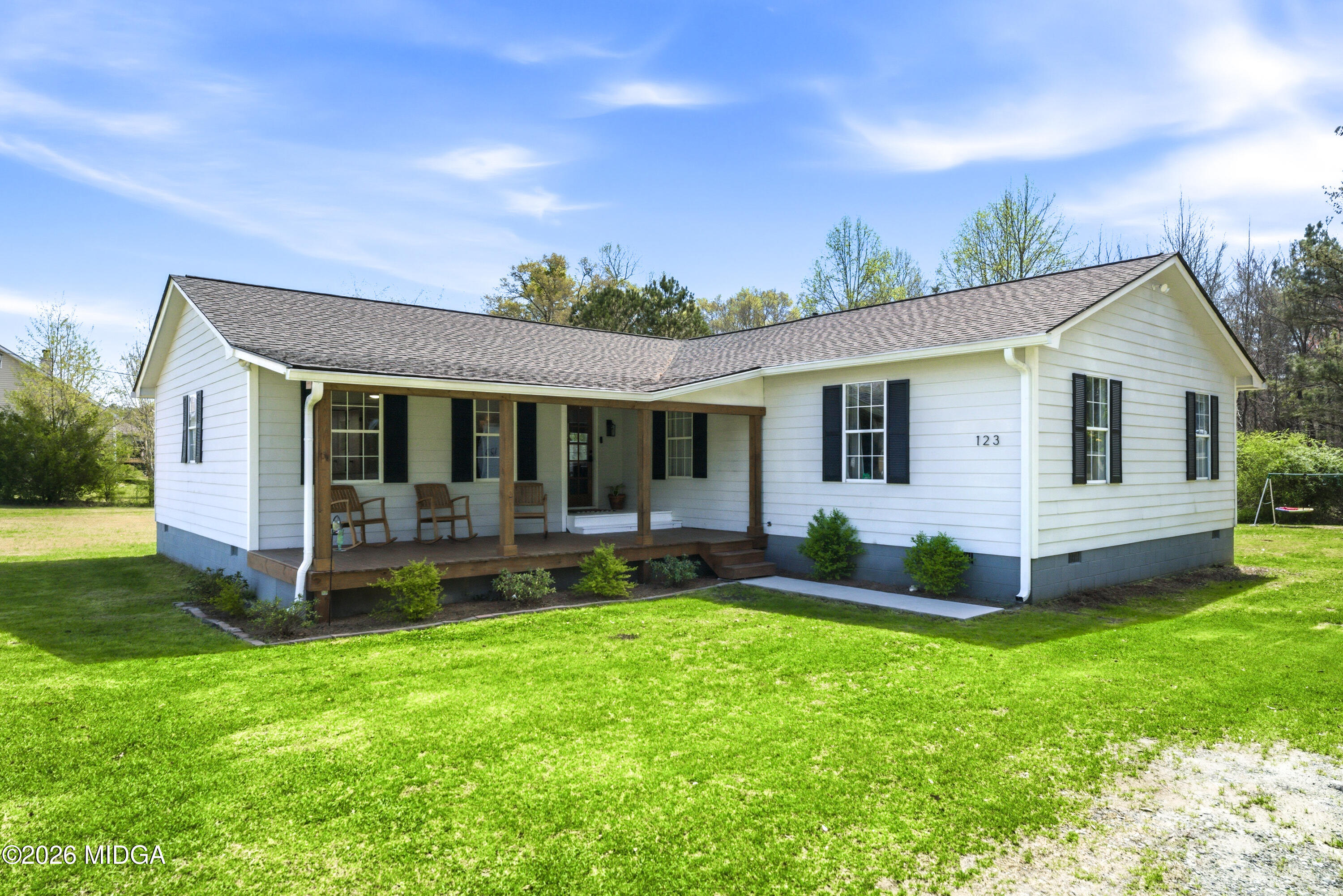 a view of a house with a yard and sitting area