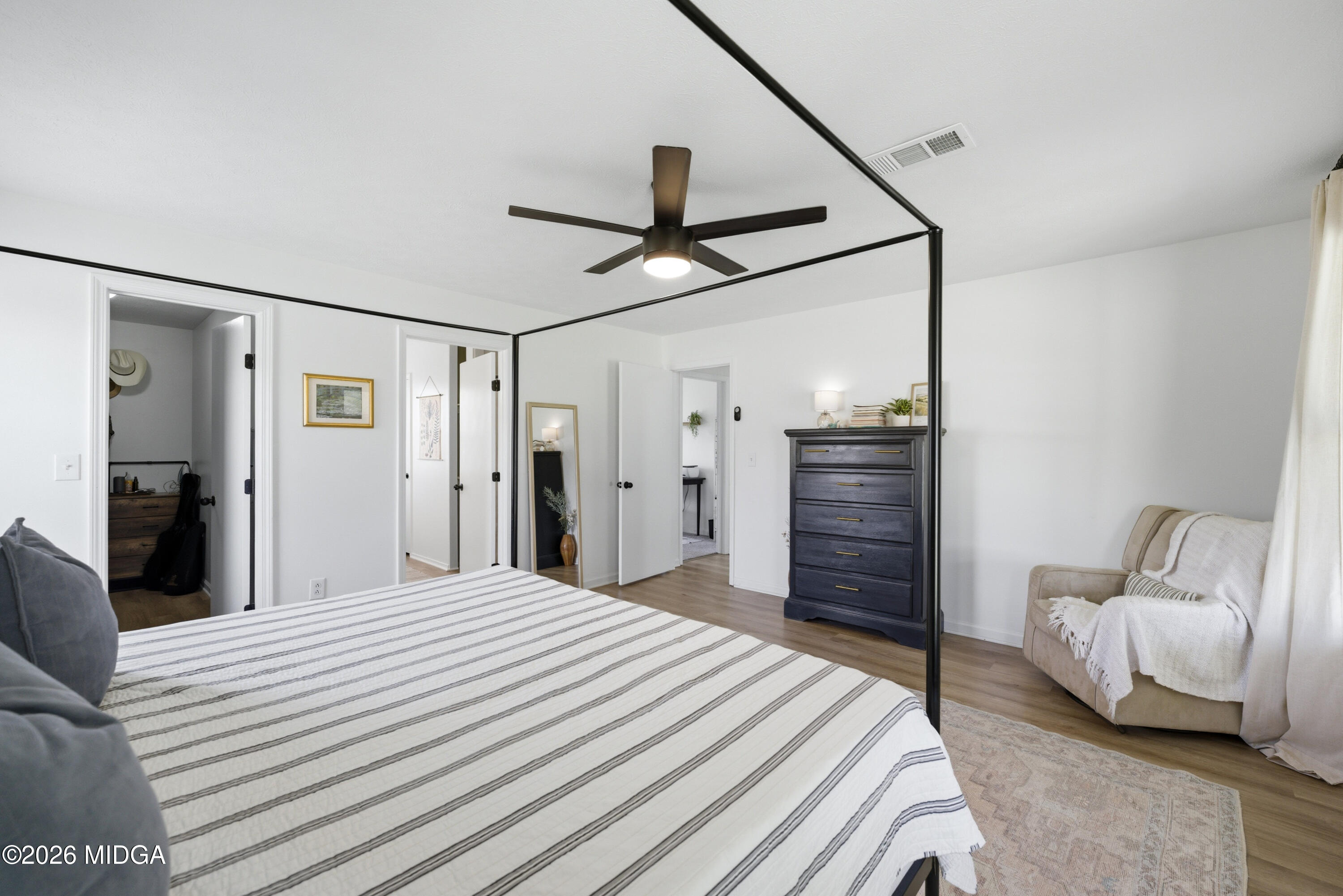123 Mathews Road Milner, GA 30257 - Photo 17 of 51 a bedroom with a bed ceiling fan and a wooden floor
