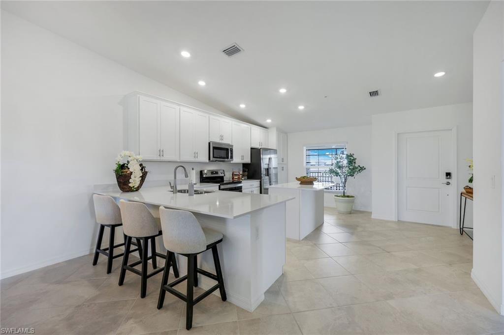 5454 Double Eagle Circle, Unit 3321 Immokalee, FL 34142 - Photo 10 of 40 a kitchen with stainless steel appliances a table and chairs in it