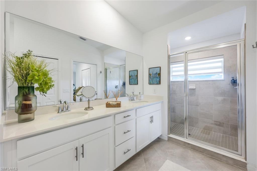 5454 Double Eagle Circle, Unit 3321 Immokalee, FL 34142 - Photo 16 of 40 a bathroom with double vanity a mirror a shower and a sink