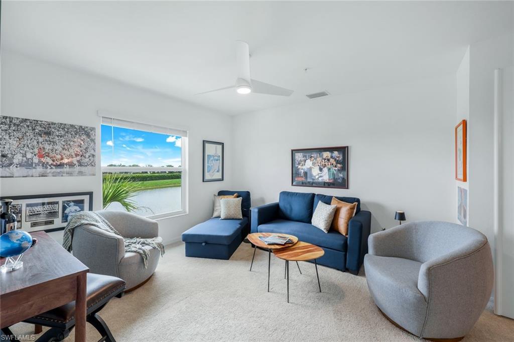 5454 Double Eagle Circle, Unit 3321 Immokalee, FL 34142 - Photo 19 of 40 a living room with furniture a flat screen tv and a large window