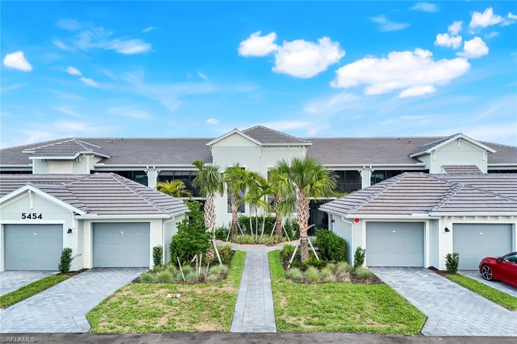 5454 Double Eagle Circle, Unit 3321 Immokalee, FL 34142 - Photo 2 of 40 a front view of a house with a yard and potted plants