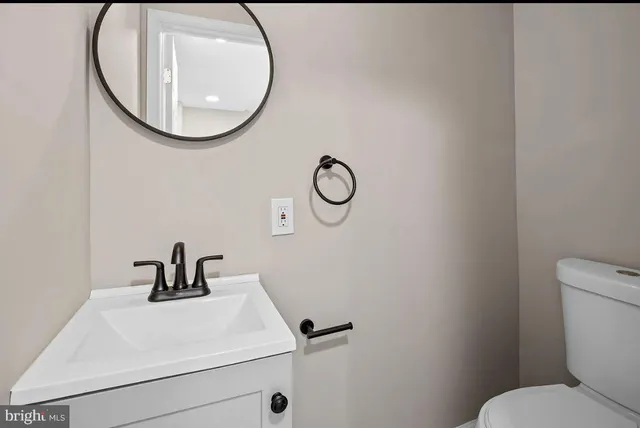 a bathroom with a sink mirror and toilet