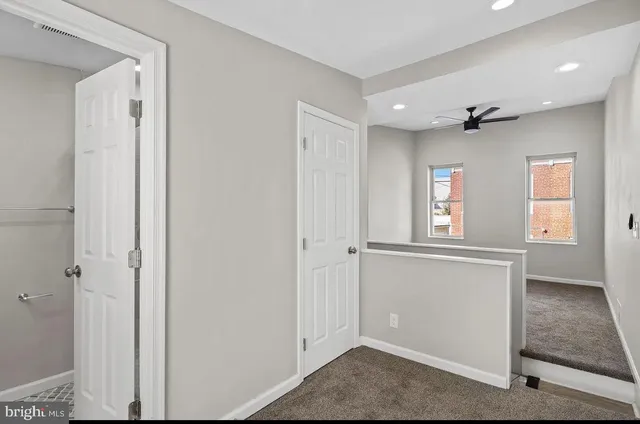 a view of a hallway with windows and chandelier