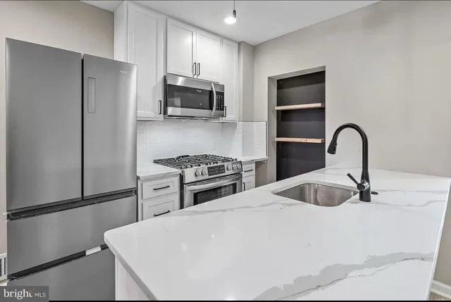 a kitchen with stainless steel appliances a refrigerator stove and microwave