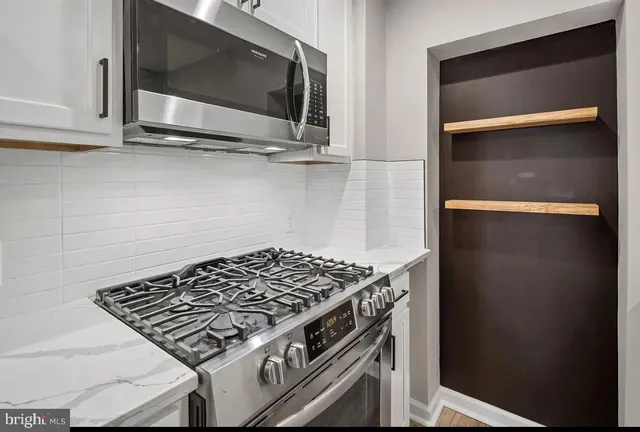 a stove top oven sitting inside of a kitchen