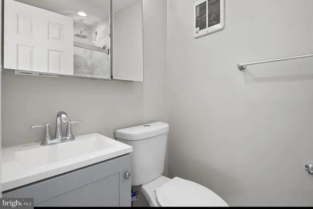 a bathroom with a toilet a sink and mirror