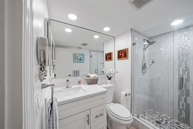 a bathroom with a sink toilet double vanity and shower